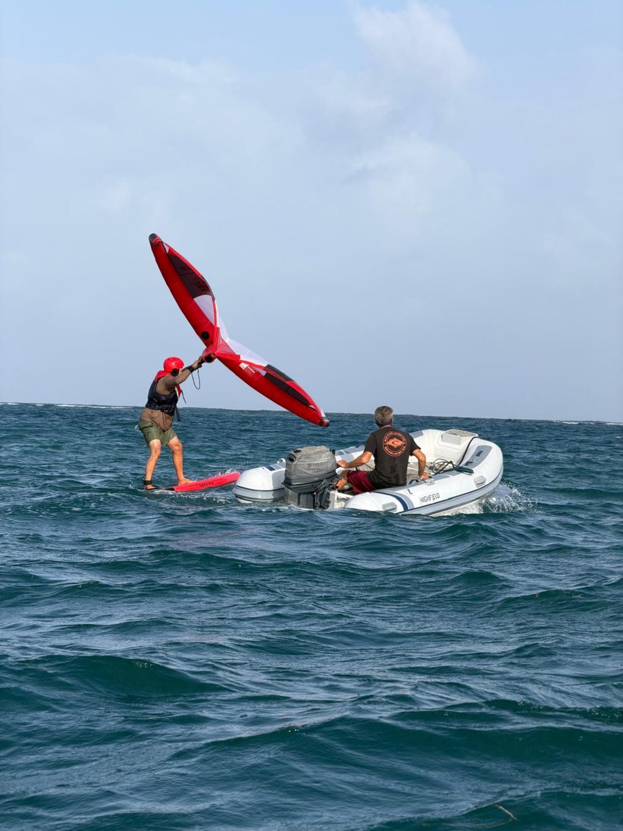 Student wingfoiling with Andi alongside in the rescue dinghy